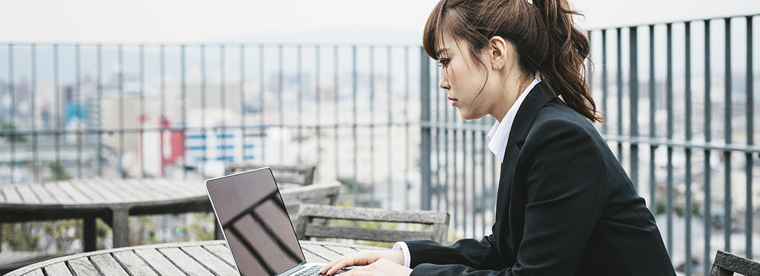 A woman in Kyoto, Japan, works on a laptop outside